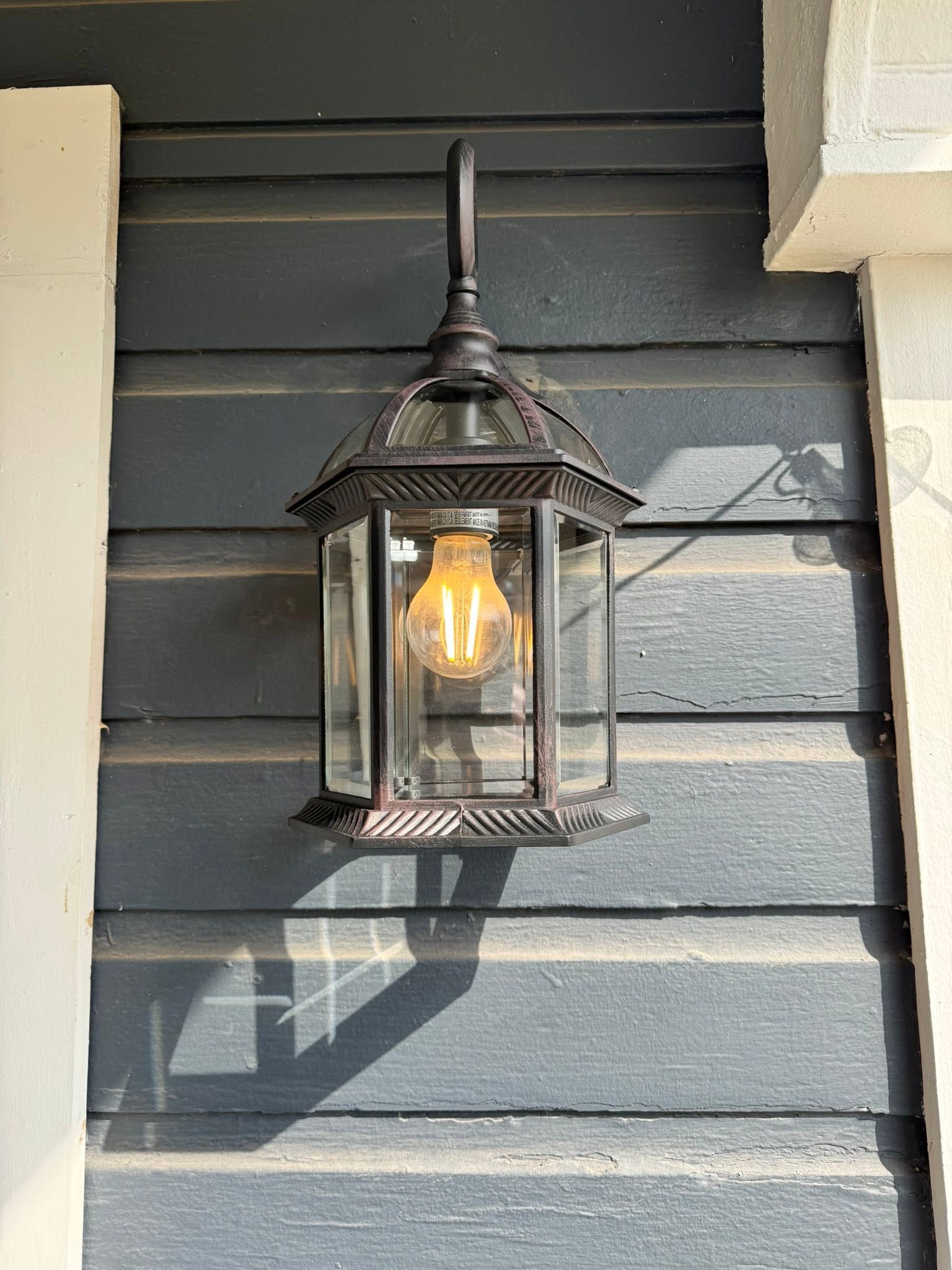 Outdoor lantern light fixture mounted on house siding